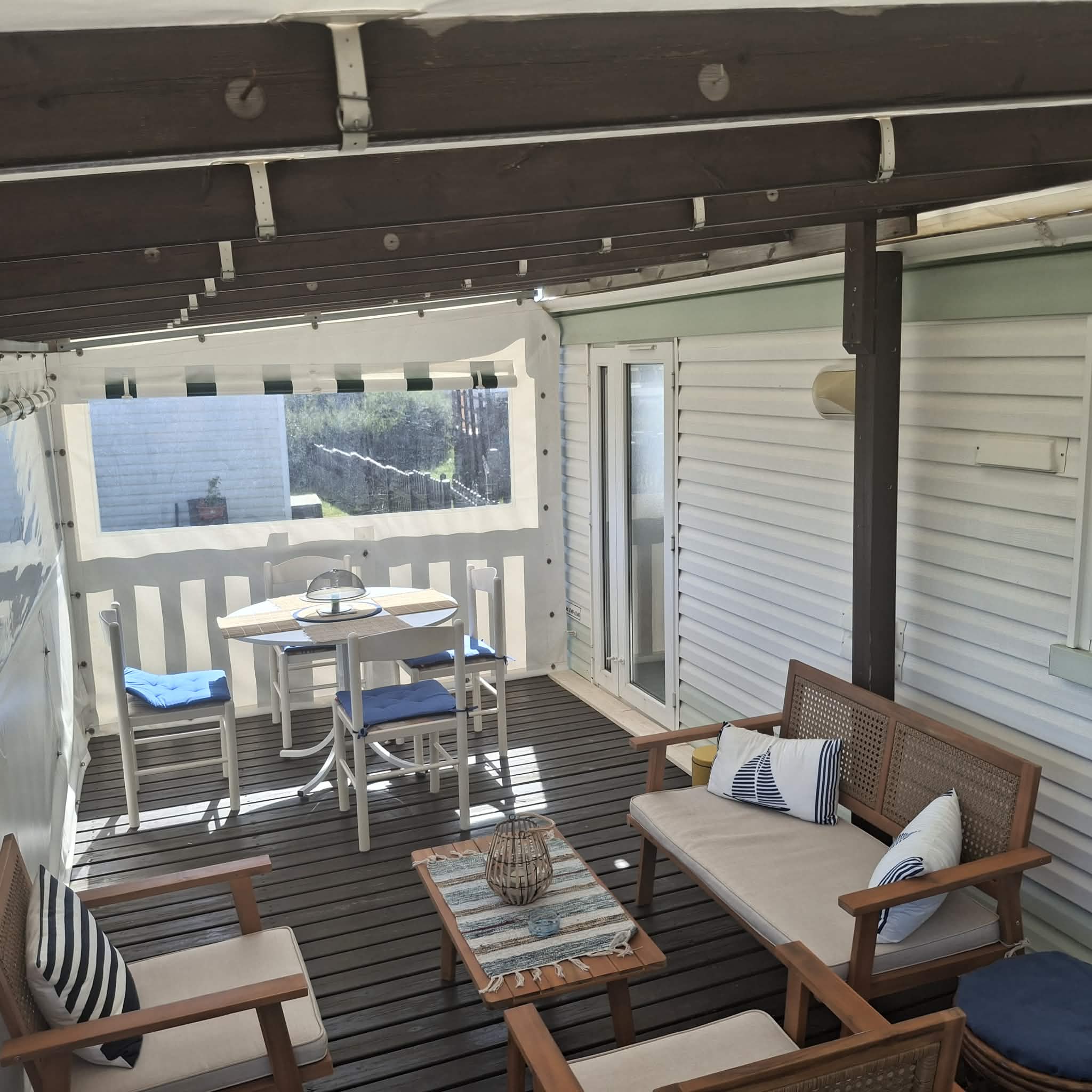 Salon extérieur et coin repas sur la terrasse couverte